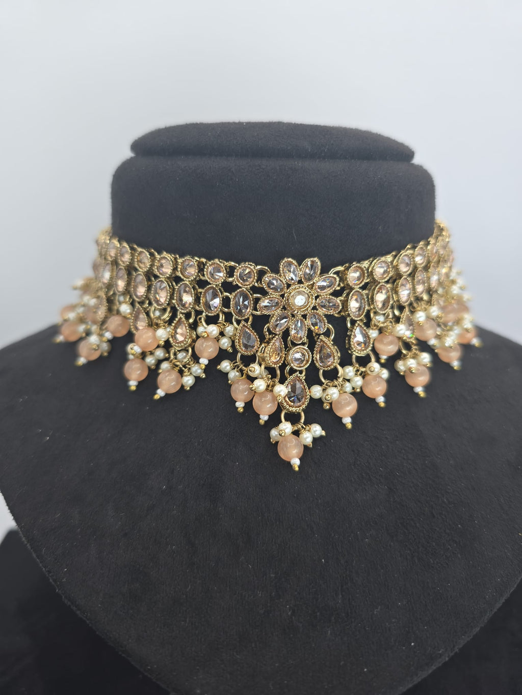 light peach polki choker set with jhumka earings and tikka