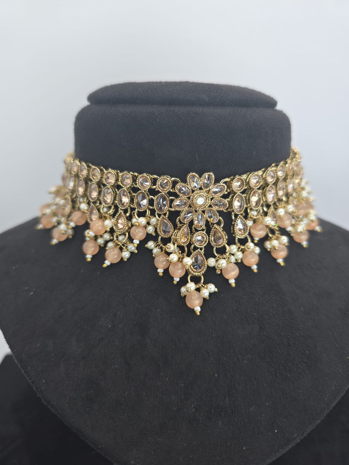 light peach polki choker set with jhumka earings and tikka